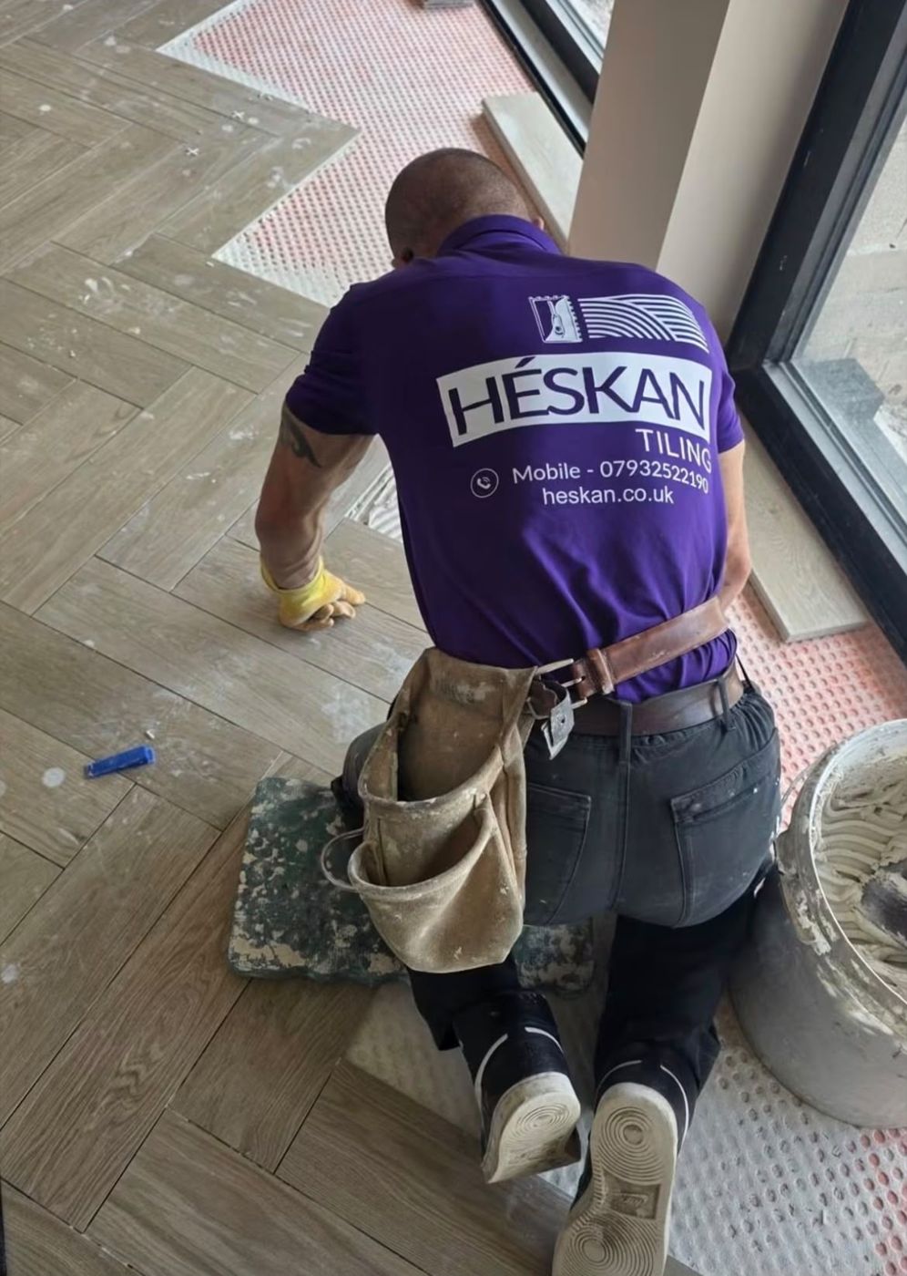 Kenny at work in his Héskan Tiling shirt, laying a herringbone floor